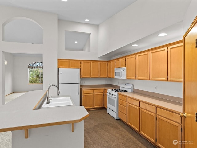 kitchen with sink, dark colored carpet, high vaulted ceiling, white appliances, and a kitchen island with sink