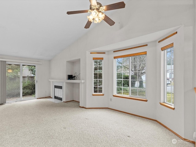 unfurnished living room featuring vaulted ceiling, plenty of natural light, and carpet floors