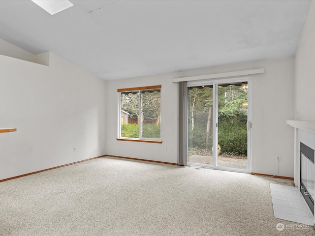 unfurnished living room with light colored carpet and a skylight