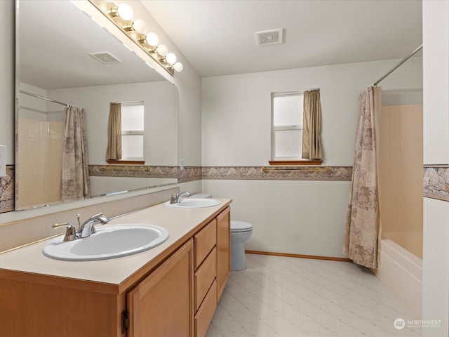 full bathroom featuring shower / bath combination with curtain, vanity, toilet, and a healthy amount of sunlight