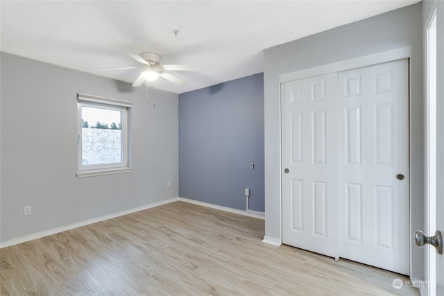 unfurnished bedroom featuring ceiling fan, light hardwood / wood-style floors, and a closet