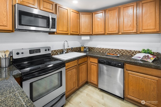 kitchen featuring sink, light hardwood / wood-style floors, and appliances with stainless steel finishes