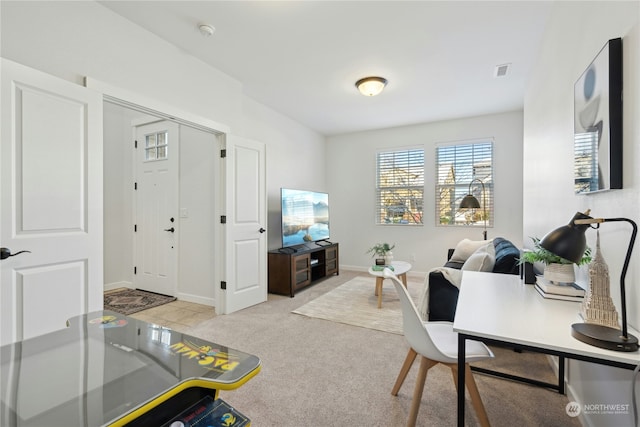 home office featuring baseboards, visible vents, and light colored carpet