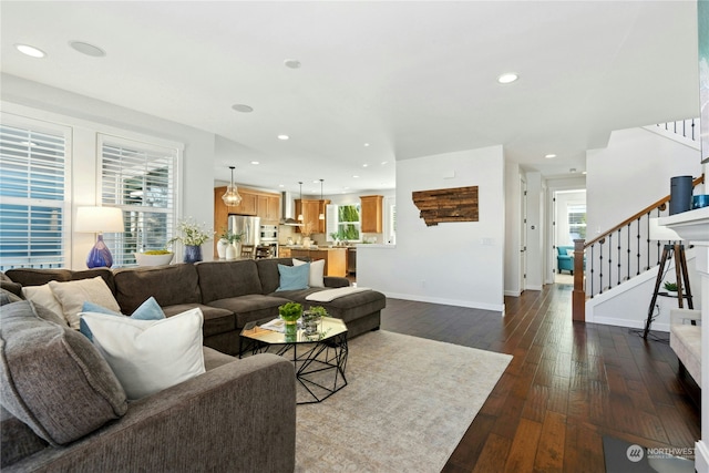 living room featuring recessed lighting, a wealth of natural light, stairway, dark wood-type flooring, and baseboards