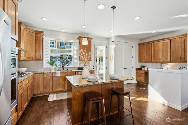 kitchen featuring dark hardwood / wood-style flooring, hanging light fixtures, plenty of natural light, and a kitchen island