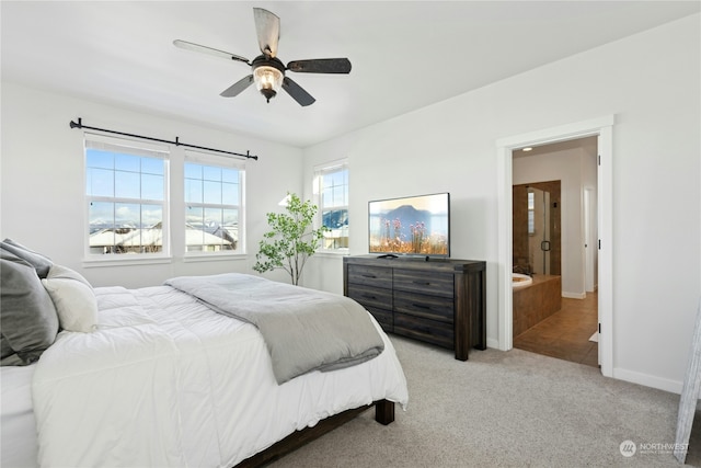 bedroom with ceiling fan, connected bathroom, and light carpet