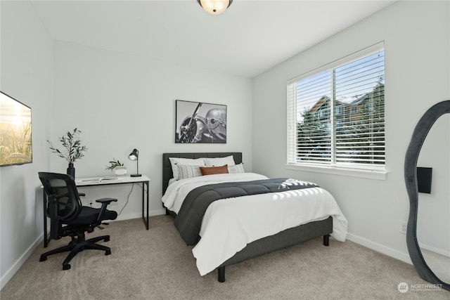 bedroom with baseboards and light colored carpet