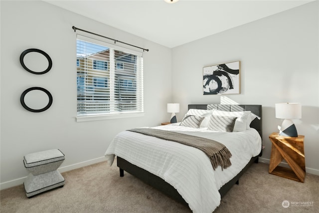 bedroom with baseboards, multiple windows, and light colored carpet