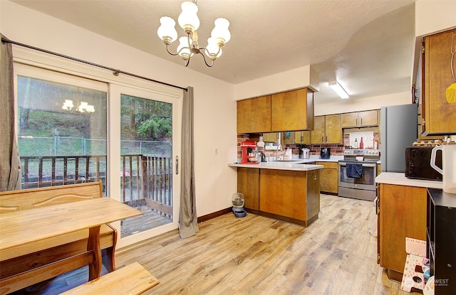 kitchen featuring hanging light fixtures, stainless steel electric range oven, a notable chandelier, and kitchen peninsula