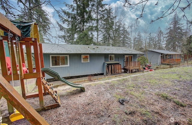 back of house with a playground