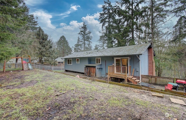 back of house with a playground