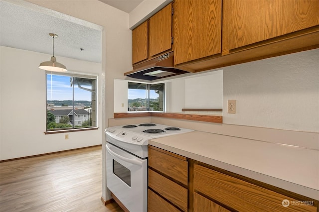 kitchen featuring hanging light fixtures, white electric range, a textured ceiling, and light wood-type flooring