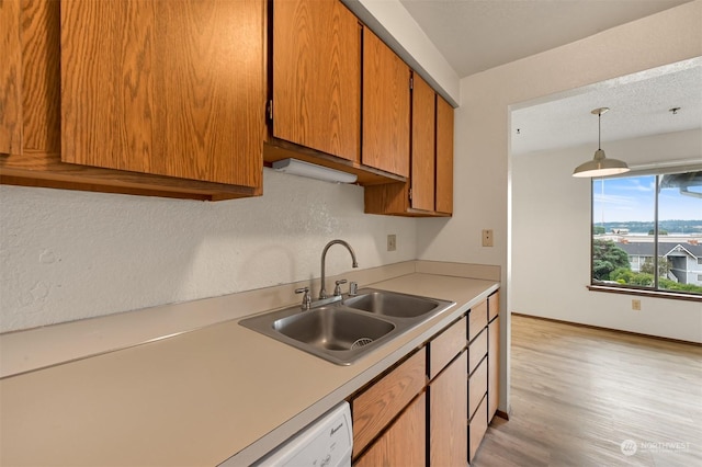 kitchen featuring pendant lighting, sink, and light wood-type flooring