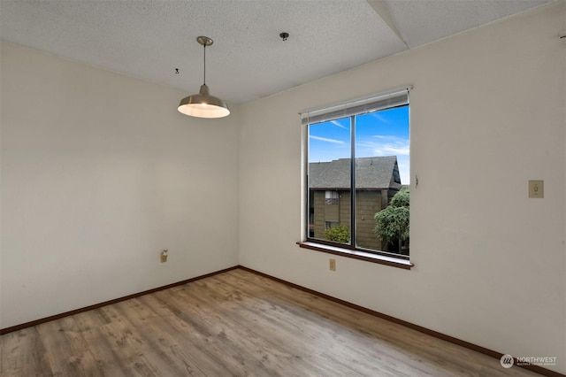 spare room with hardwood / wood-style flooring and a textured ceiling