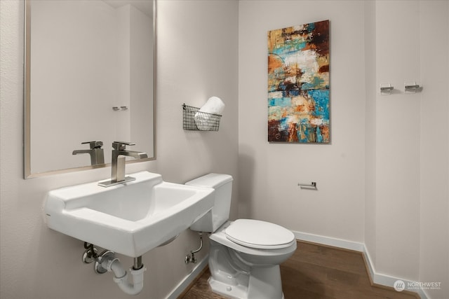 bathroom with wood-type flooring, toilet, and sink