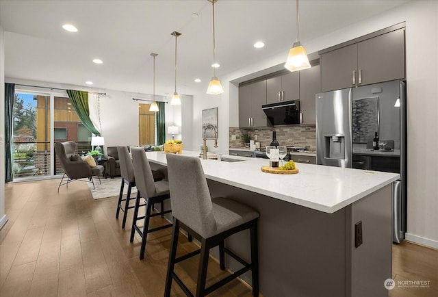 kitchen with pendant lighting, sink, a breakfast bar area, and gray cabinetry