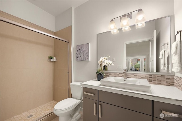 bathroom featuring vanity, toilet, and tiled shower