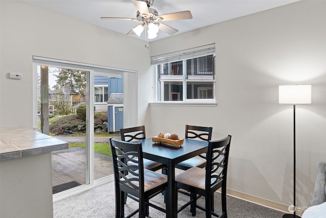 carpeted dining space featuring ceiling fan