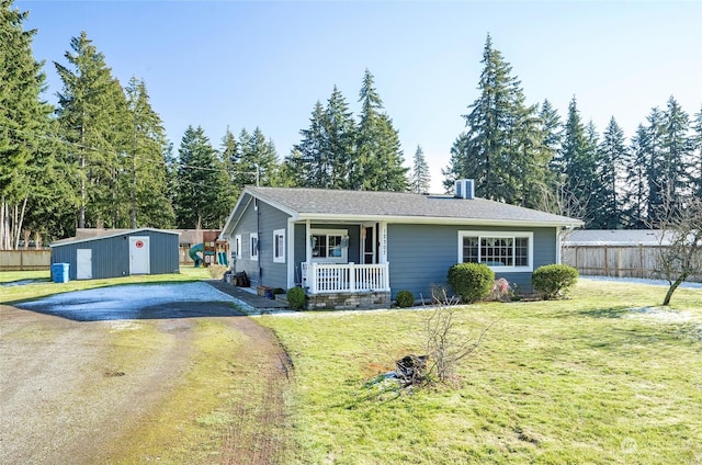 ranch-style house with an outbuilding, a porch, and a front yard