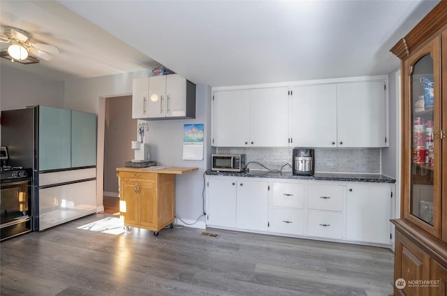 kitchen featuring white cabinetry, light wood-type flooring, refrigerator, and gas stove