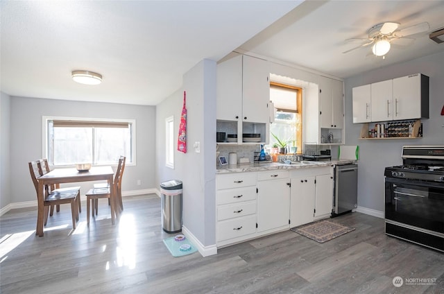 kitchen featuring hardwood / wood-style flooring, white cabinetry, black gas stove, and stainless steel dishwasher