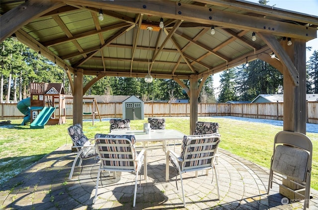 view of patio featuring a playground, a gazebo, and a shed