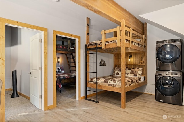 bedroom with stacked washer / dryer and light hardwood / wood-style flooring