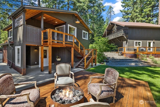 rear view of property featuring a wooden deck and an outdoor fire pit