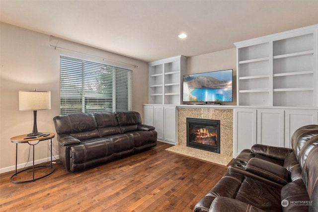 living area with built in features, dark wood-style flooring, a fireplace, recessed lighting, and baseboards