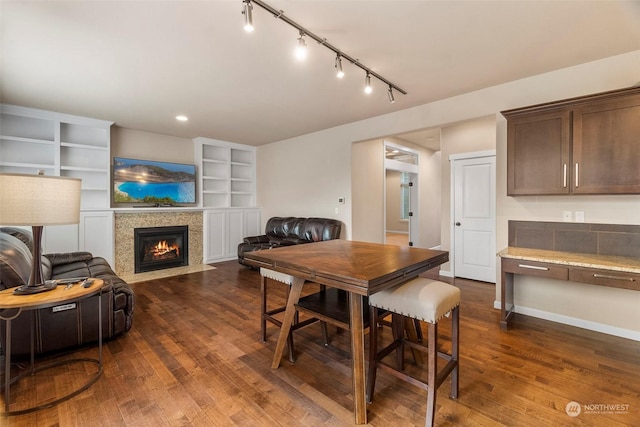 dining area with a fireplace with flush hearth, baseboards, dark wood finished floors, and recessed lighting