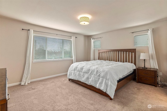 bedroom featuring light carpet and baseboards