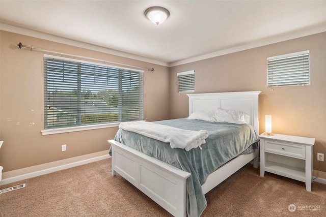 bedroom featuring carpet floors, visible vents, ornamental molding, and baseboards