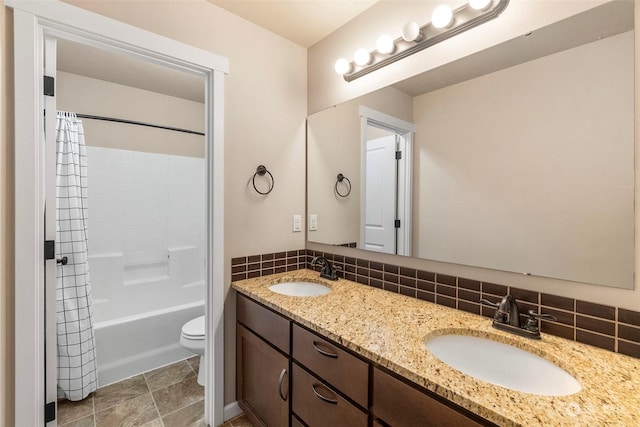 bathroom featuring tasteful backsplash, a sink, toilet, and double vanity