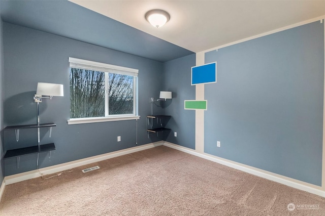 carpeted spare room featuring visible vents and baseboards