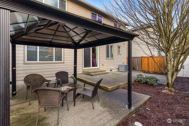 view of patio / terrace with entry steps, a gazebo, fence, and central air condition unit