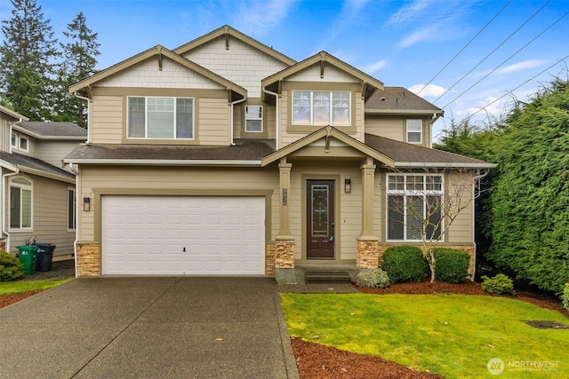 craftsman inspired home with driveway, stone siding, a garage, and a front yard