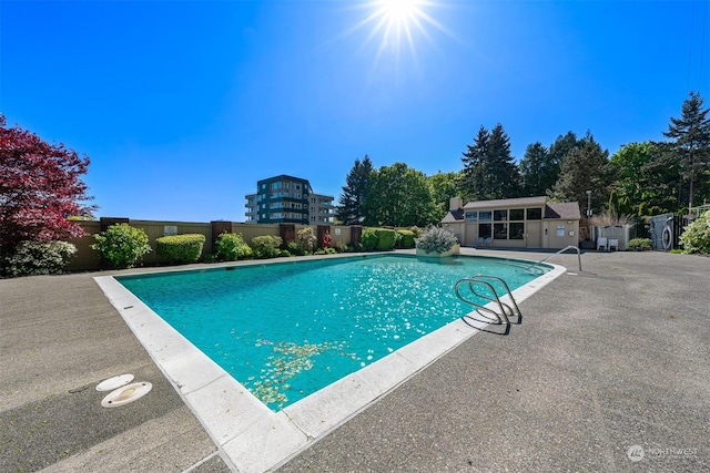 view of pool with an outbuilding and a patio