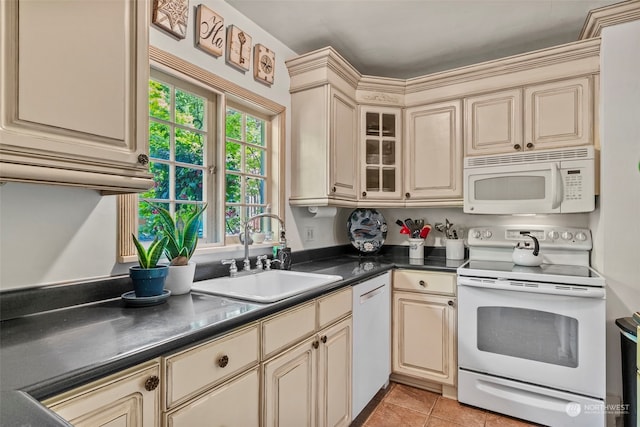 kitchen featuring white appliances, sink, and cream cabinetry