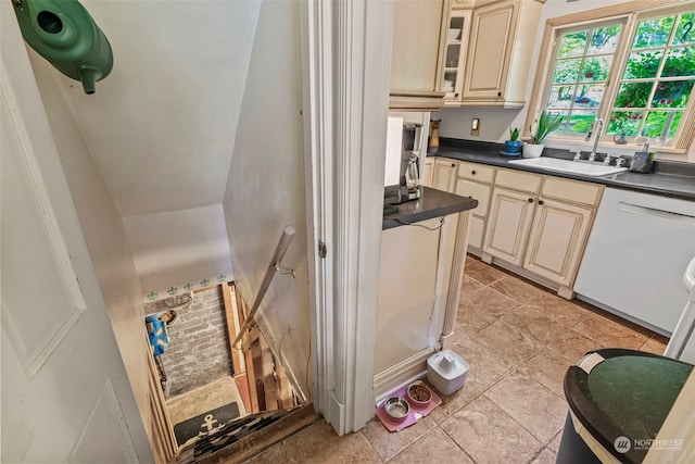 kitchen with dishwasher, sink, and cream cabinetry