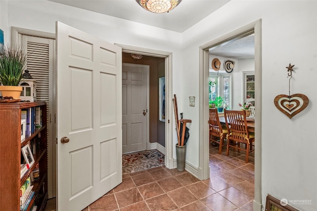 hall with dark tile patterned floors