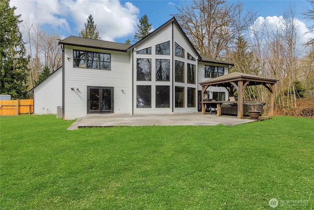 back of house featuring fence, a patio, a gazebo, a hot tub, and a yard