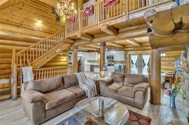 living room featuring an inviting chandelier, wood ceiling, rustic walls, and a high ceiling