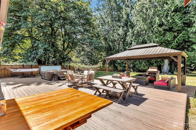 deck featuring a hot tub, a gazebo, and grilling area