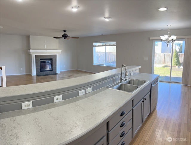 kitchen with stainless steel dishwasher, sink, pendant lighting, and gray cabinetry