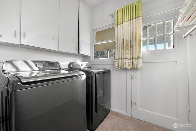 laundry area featuring cabinets, crown molding, light carpet, and washer and clothes dryer