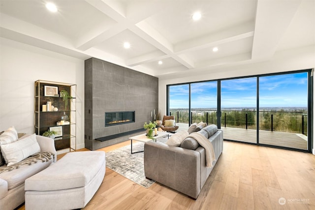 living room with beamed ceiling, a fireplace, coffered ceiling, and light wood-type flooring