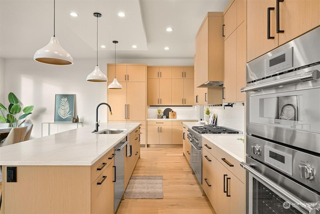 kitchen featuring sink, stainless steel appliances, a spacious island, light brown cabinetry, and decorative light fixtures