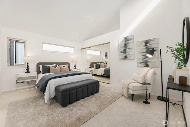 bedroom with carpet, a closet, lofted ceiling, and baseboards