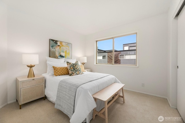 bedroom with light carpet and baseboards