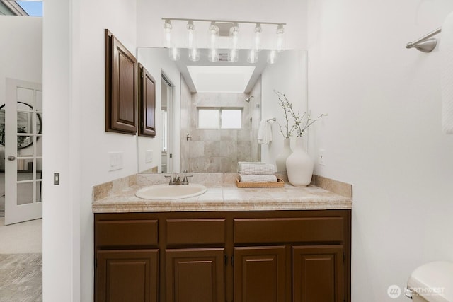 bathroom featuring a walk in shower and vanity